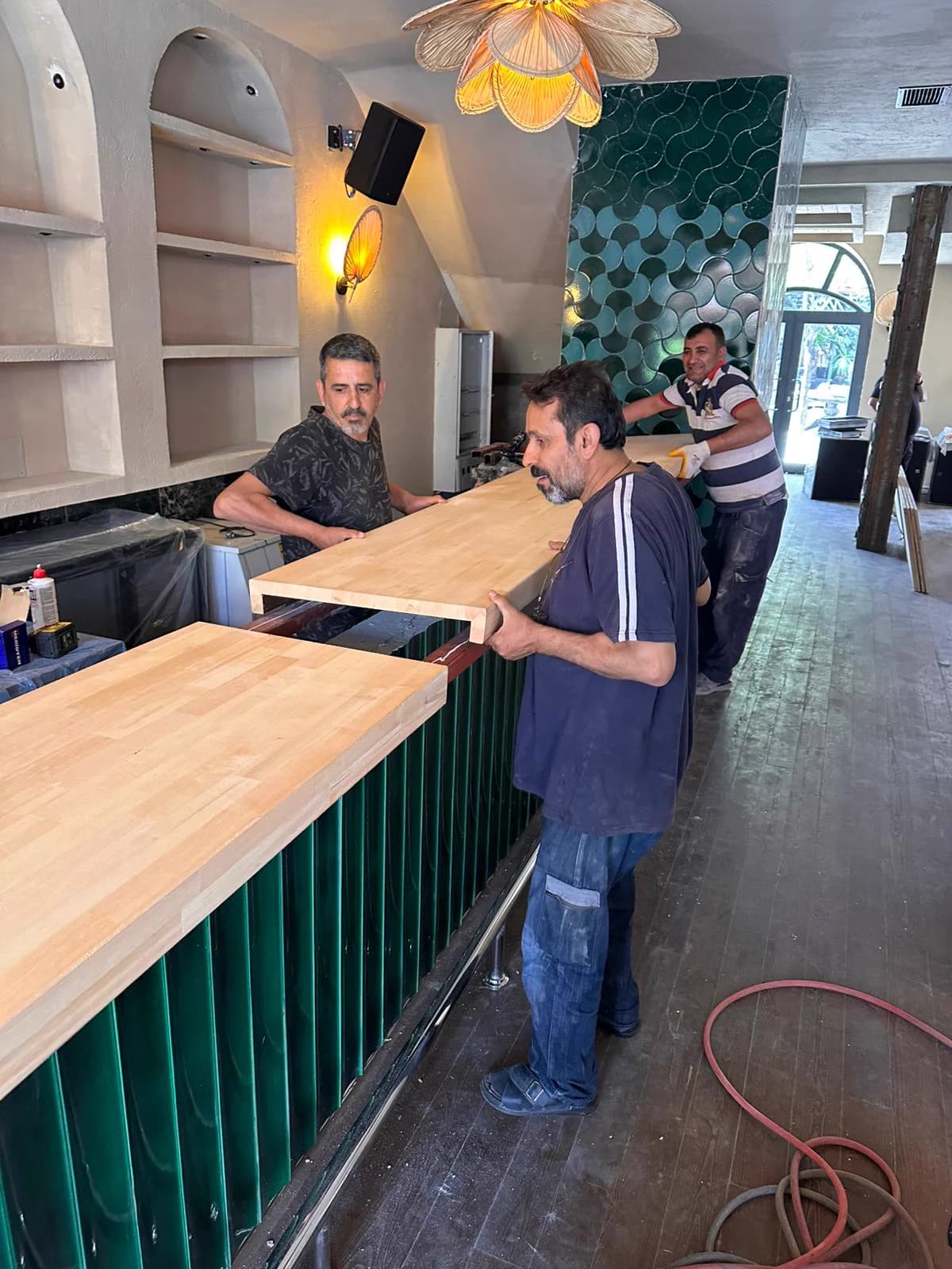 Ekibin ahşap bar tezgâhını mekânda yerine yerleştirmesi